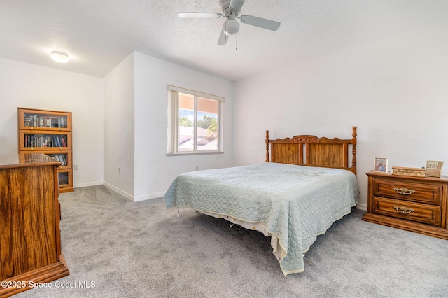 bedroom with baseboards, carpet, a ceiling fan, and a textured ceiling