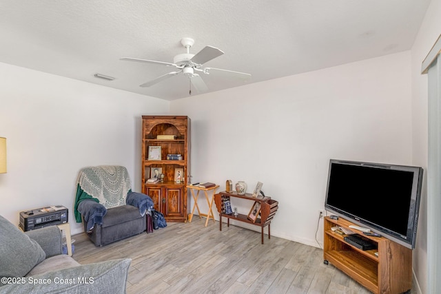 living area featuring a ceiling fan and wood finished floors