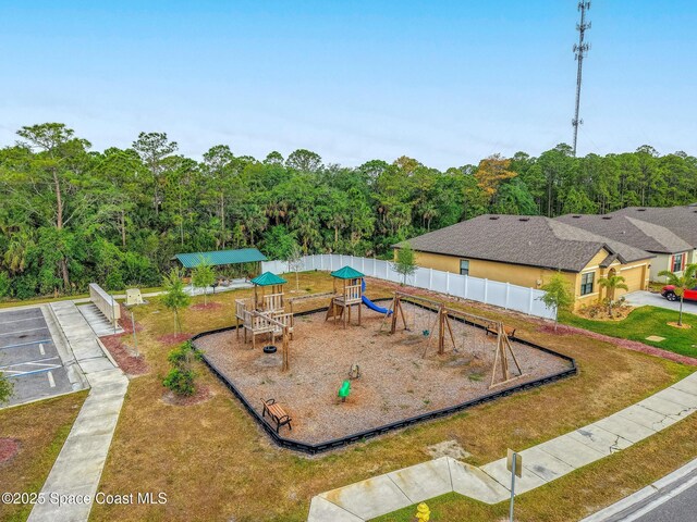 community playground with fence and a forest view