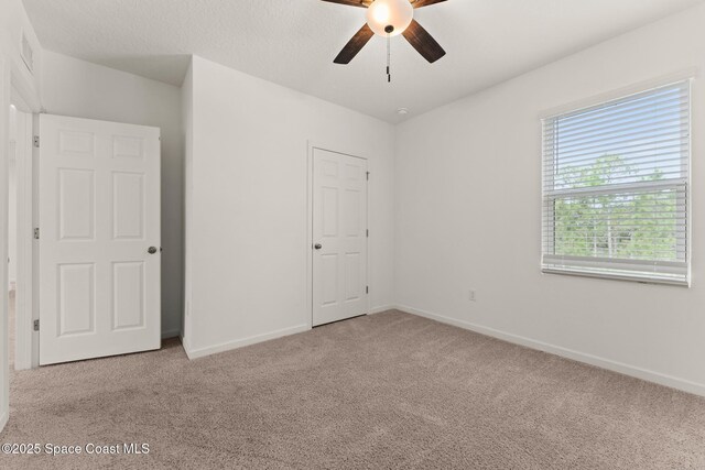 unfurnished bedroom featuring carpet flooring, baseboards, and a ceiling fan