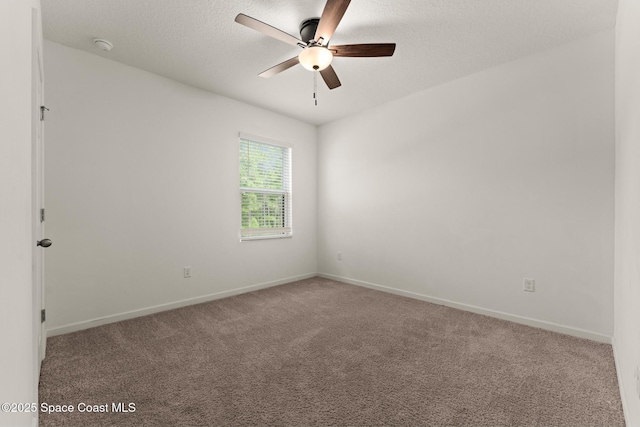carpeted spare room featuring ceiling fan, baseboards, and a textured ceiling