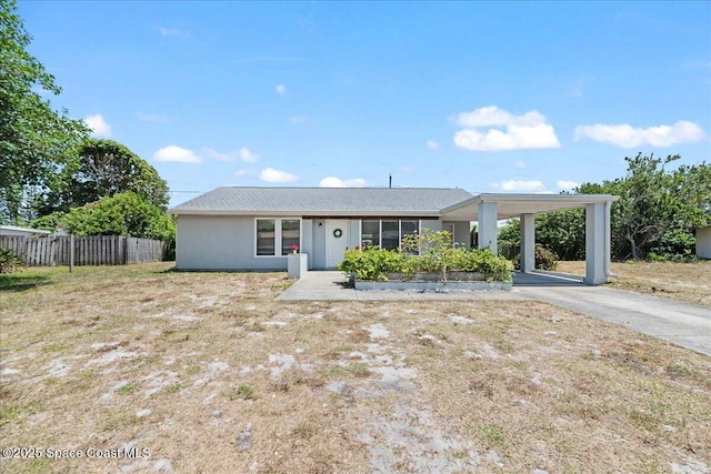 single story home with aphalt driveway, fence, and an attached carport