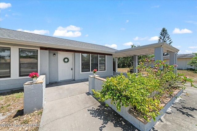 exterior space featuring roof with shingles and a patio area