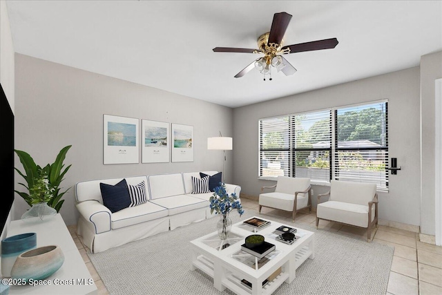 living room with light tile patterned floors, baseboards, and a ceiling fan