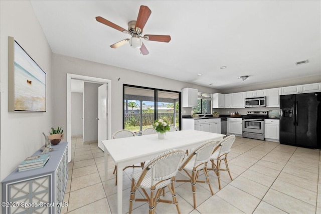 dining area with light tile patterned flooring, a ceiling fan, and visible vents