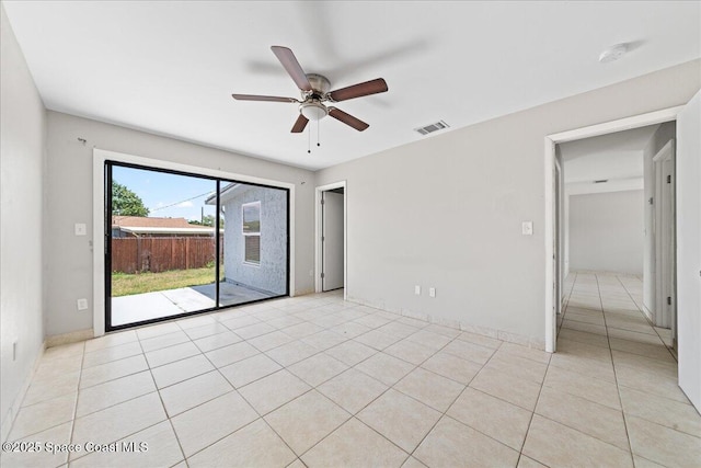 unfurnished room with light tile patterned flooring, ceiling fan, visible vents, and baseboards