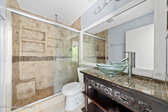full bathroom featuring vanity, tile patterned flooring, a stall shower, and toilet