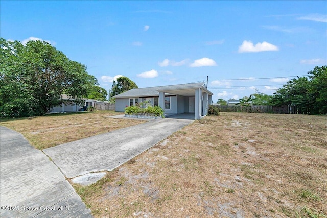 view of front of property featuring a front lawn, aphalt driveway, fence, and a carport
