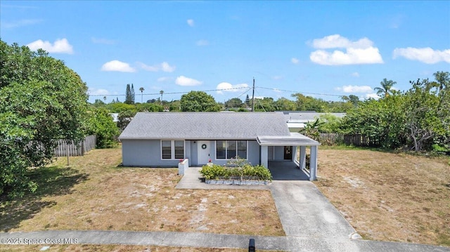 view of front facade with fence, a carport, a front lawn, and aphalt driveway