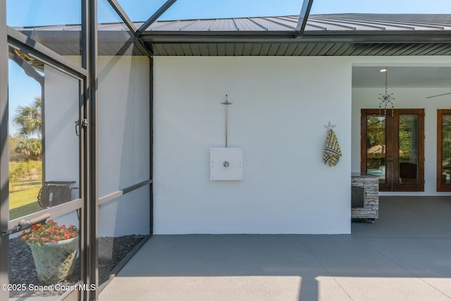 exterior space with a patio, stucco siding, french doors, a standing seam roof, and metal roof