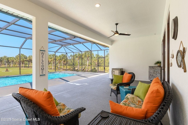 view of patio featuring a lanai, a ceiling fan, and an outdoor pool