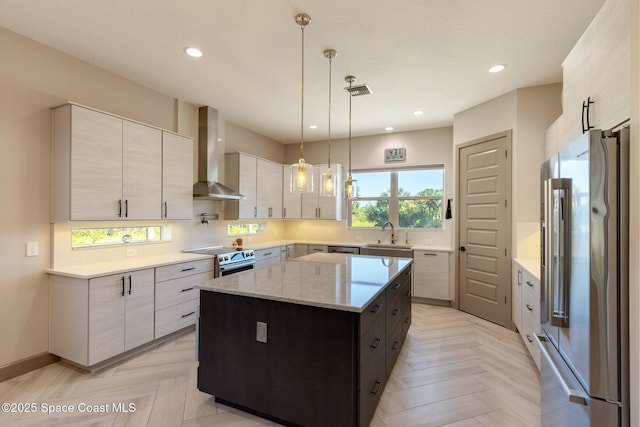kitchen featuring wall chimney range hood, decorative backsplash, a kitchen island, stainless steel appliances, and recessed lighting