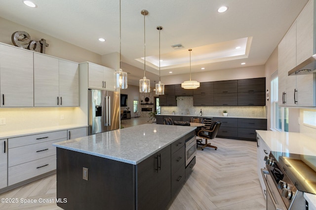 kitchen featuring backsplash, a kitchen island, visible vents, appliances with stainless steel finishes, and modern cabinets