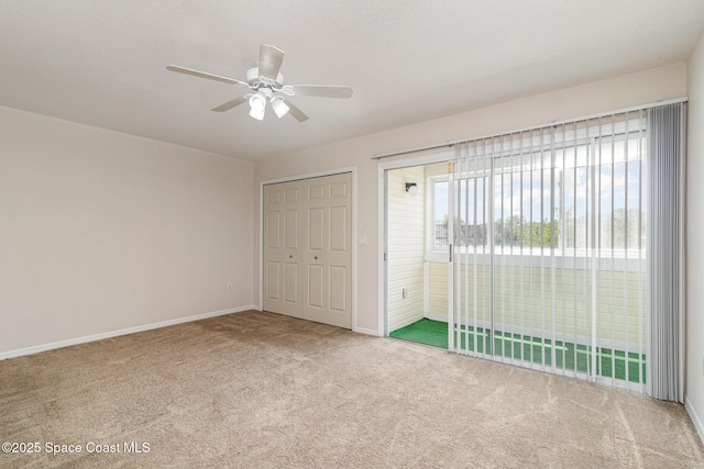 unfurnished bedroom featuring carpet flooring, a ceiling fan, baseboards, and access to exterior