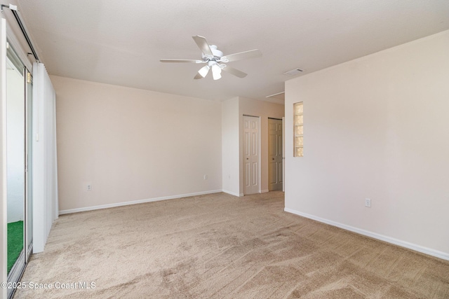unfurnished room featuring light colored carpet, a ceiling fan, baseboards, and visible vents