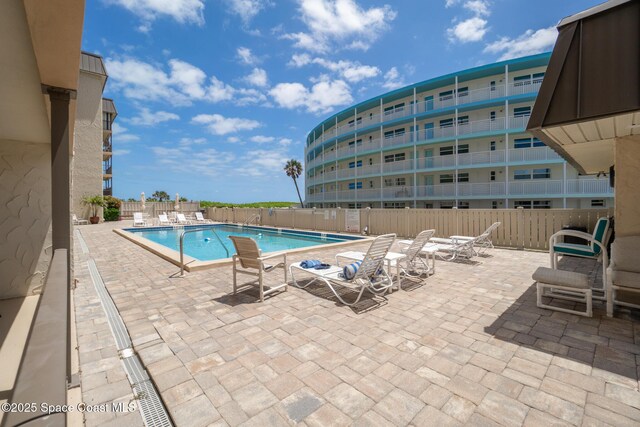 community pool featuring fence and a patio area