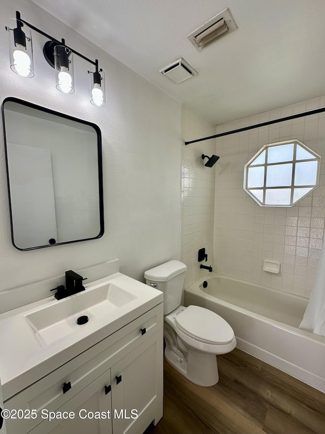 bathroom with visible vents, shower / tub combo, wood finished floors, and toilet