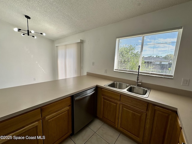 kitchen featuring a textured ceiling, stainless steel dishwasher, a sink, light tile patterned floors, and an inviting chandelier