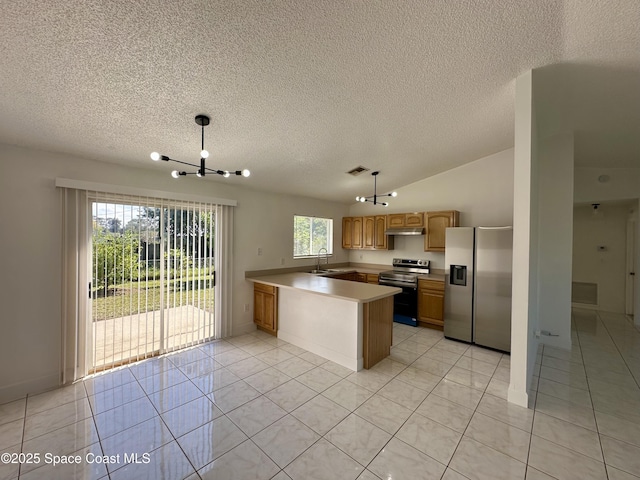 kitchen with a sink, appliances with stainless steel finishes, light tile patterned floors, and a textured ceiling