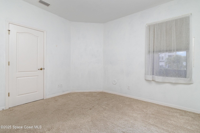 carpeted spare room featuring baseboards
