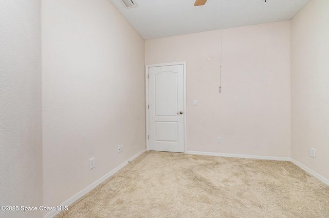 carpeted spare room featuring ceiling fan and baseboards