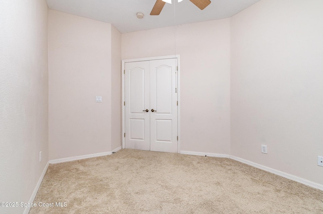 spare room featuring ceiling fan, carpet floors, baseboards, and a smoke detector