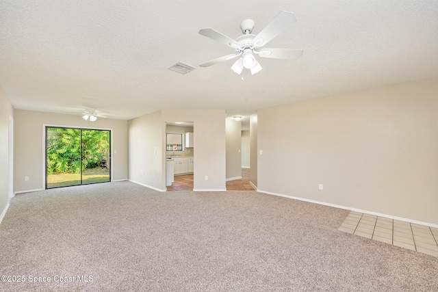 spare room with ceiling fan, visible vents, light carpet, and baseboards