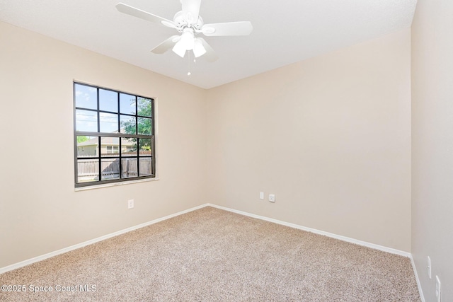 carpeted spare room with baseboards and a ceiling fan