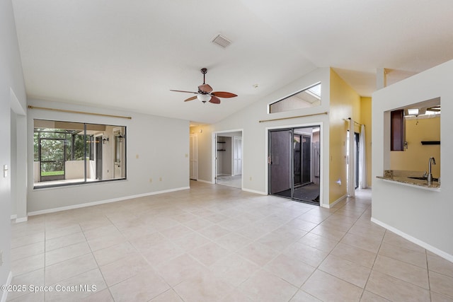 empty room featuring a sink, lofted ceiling, visible vents, ceiling fan, and light tile patterned floors