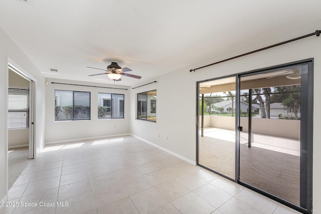 spare room featuring visible vents, a ceiling fan, baseboards, and light tile patterned flooring