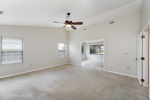 spare room with lofted ceiling, a ceiling fan, baseboards, visible vents, and light colored carpet