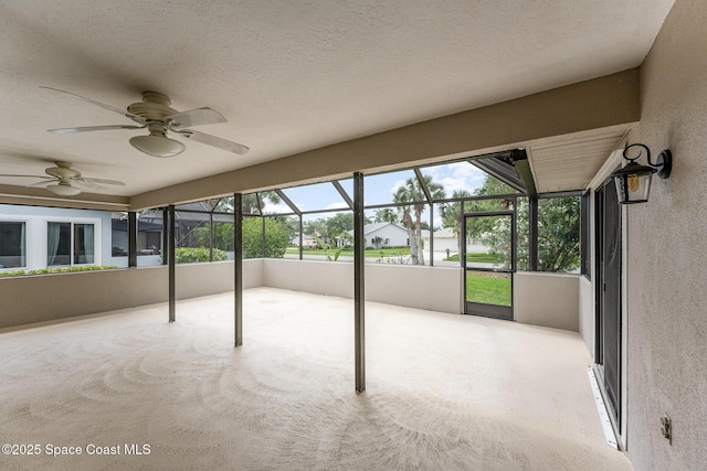 unfurnished sunroom with ceiling fan