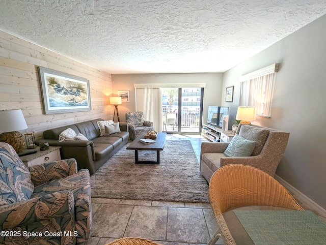 living room with wooden walls, a textured ceiling, and stone finish flooring
