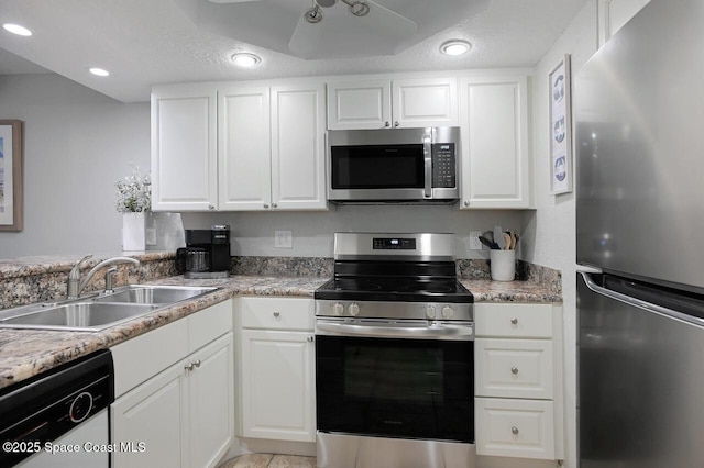 kitchen with a sink, appliances with stainless steel finishes, ceiling fan, and white cabinetry