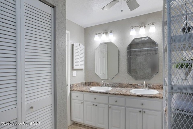 full bathroom featuring a closet, a sink, and a textured wall
