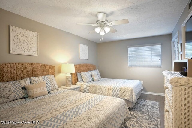 bedroom with baseboards, a textured ceiling, ceiling fan, and wood finished floors