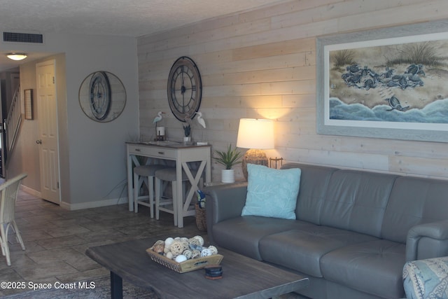 5350 Ocean Beach Blvd Unit 207, Cocoa Beach, FL 32931 - living room featuring wooden walls, stone finish floors, and baseboards