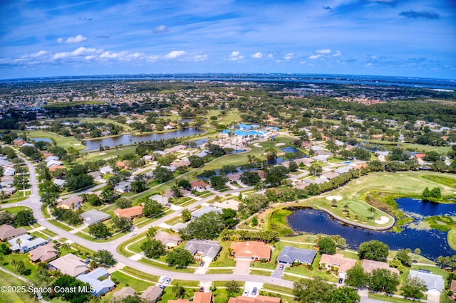 drone / aerial view featuring a water view, view of golf course, and a residential view