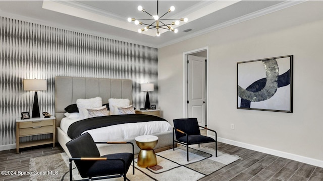 bedroom with wood tiled floor, ornamental molding, a raised ceiling, and a notable chandelier