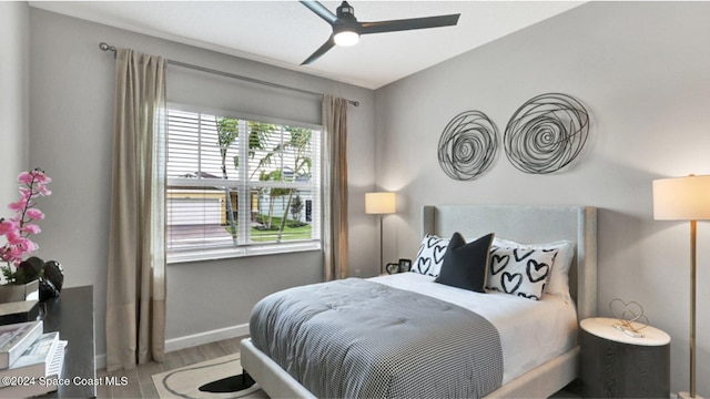 bedroom with baseboards, ceiling fan, and wood finished floors