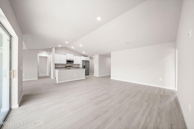 unfurnished living room with recessed lighting, baseboards, vaulted ceiling, and light wood finished floors