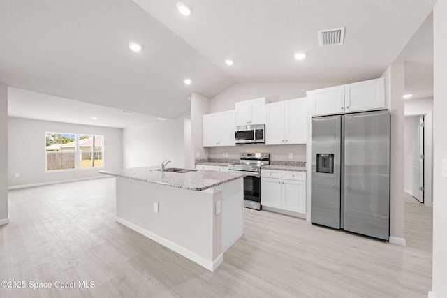 kitchen with visible vents, light wood finished floors, appliances with stainless steel finishes, and a center island with sink