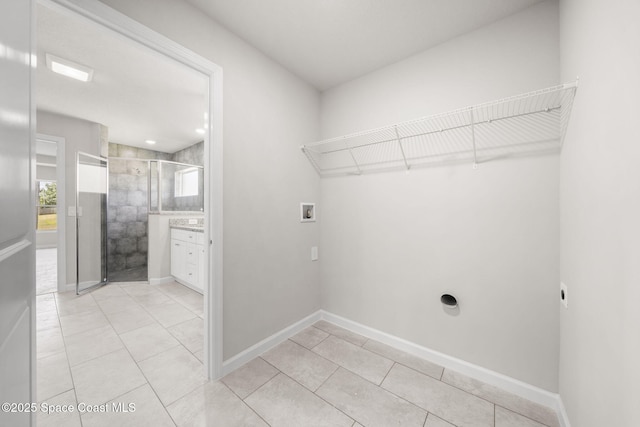 clothes washing area with hookup for an electric dryer, laundry area, light tile patterned floors, and hookup for a washing machine