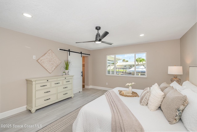 451 Bridgetown Ct, Satellite Beach, FL 32937 - bedroom featuring light wood finished floors, a barn door, baseboards, recessed lighting, and ceiling fan
