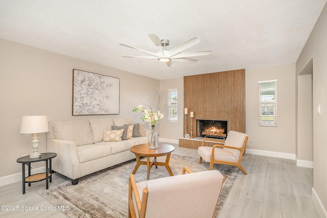 451 Bridgetown Ct, Satellite Beach, FL 32937 - living room featuring healthy amount of natural light, light wood finished floors, a ceiling fan, baseboards, and a textured ceiling