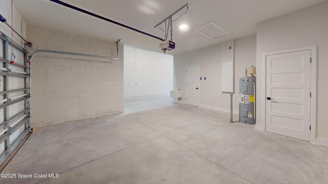 garage featuring concrete block wall, a garage door opener, and electric water heater
