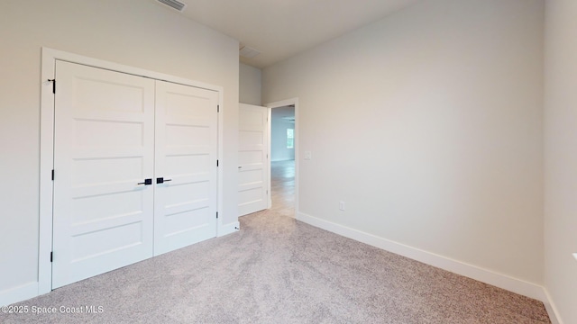 unfurnished bedroom with a closet, carpet, and baseboards
