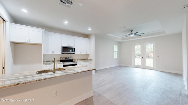 kitchen with visible vents, appliances with stainless steel finishes, a sink, baseboards, and a raised ceiling