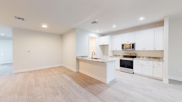 kitchen with visible vents, a sink, light wood finished floors, and stainless steel appliances
