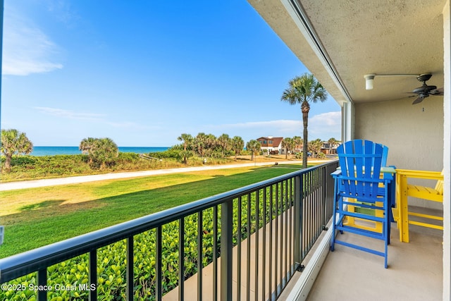 balcony featuring a water view and ceiling fan